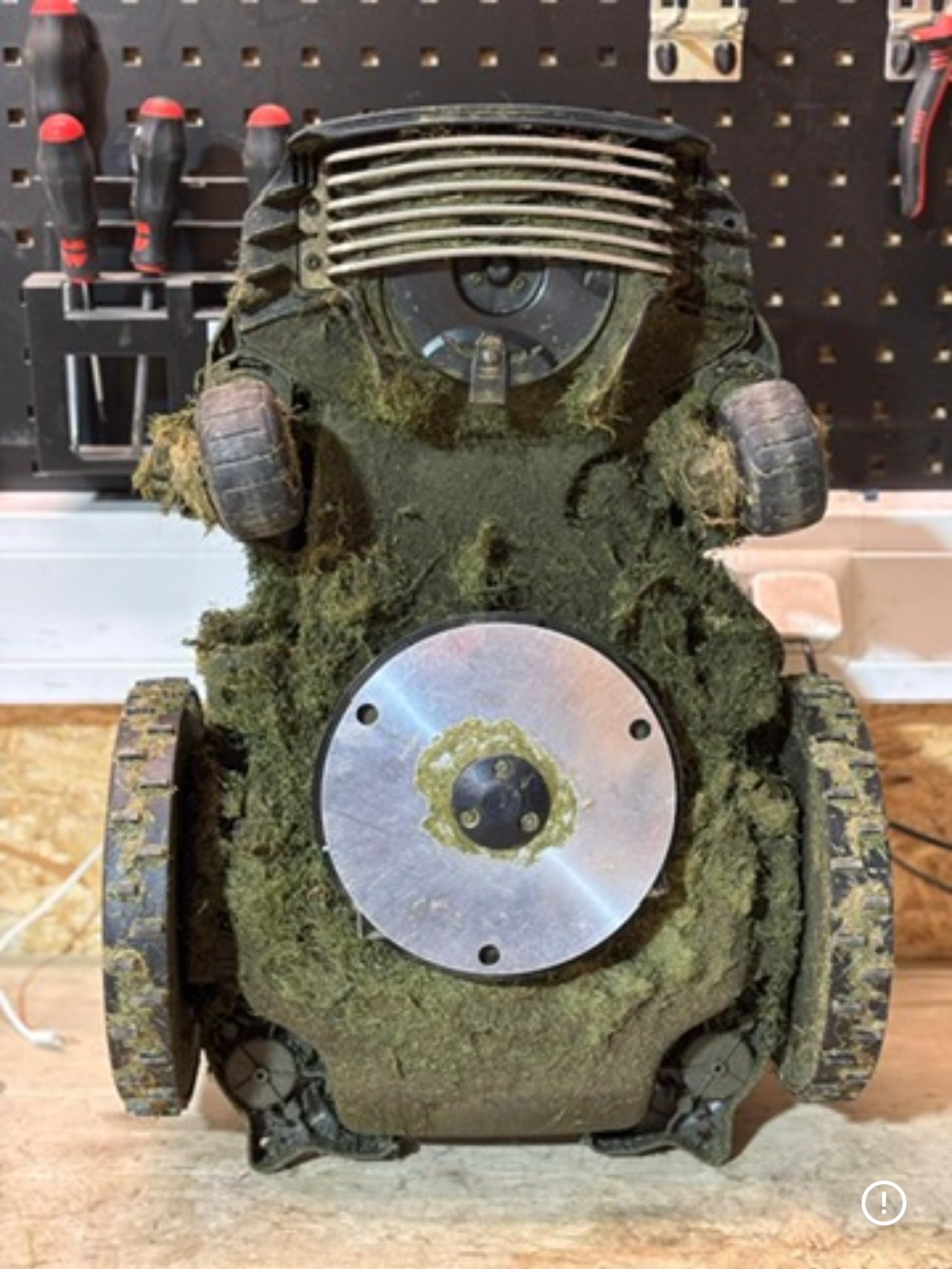 Verschmutzter Mähroboter vor der Reinigung